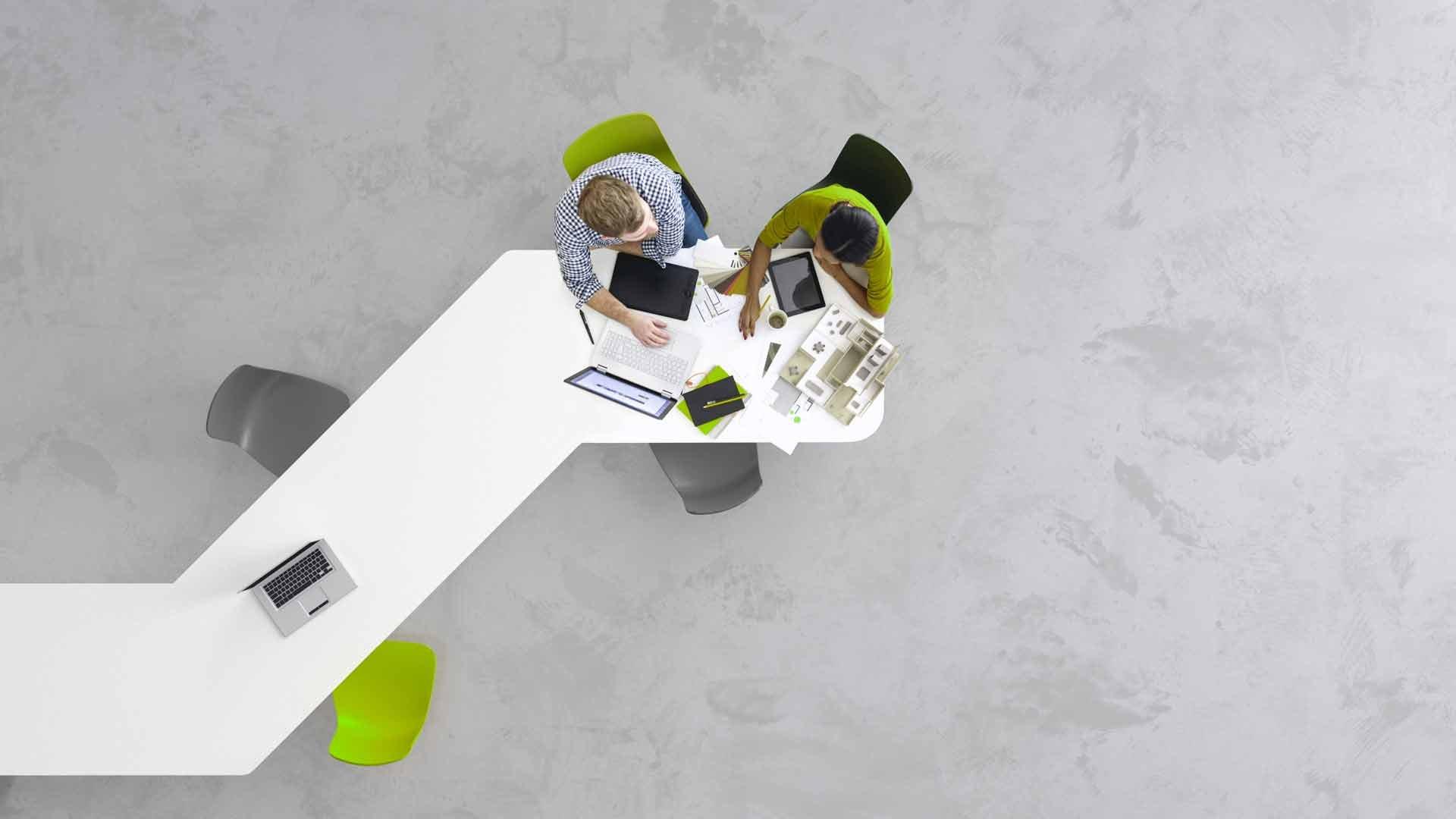 two_business_people_collaborating_at_desk_from_above