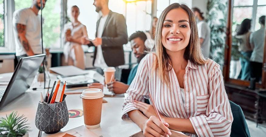 Woman at office surrounded by paperwork and people