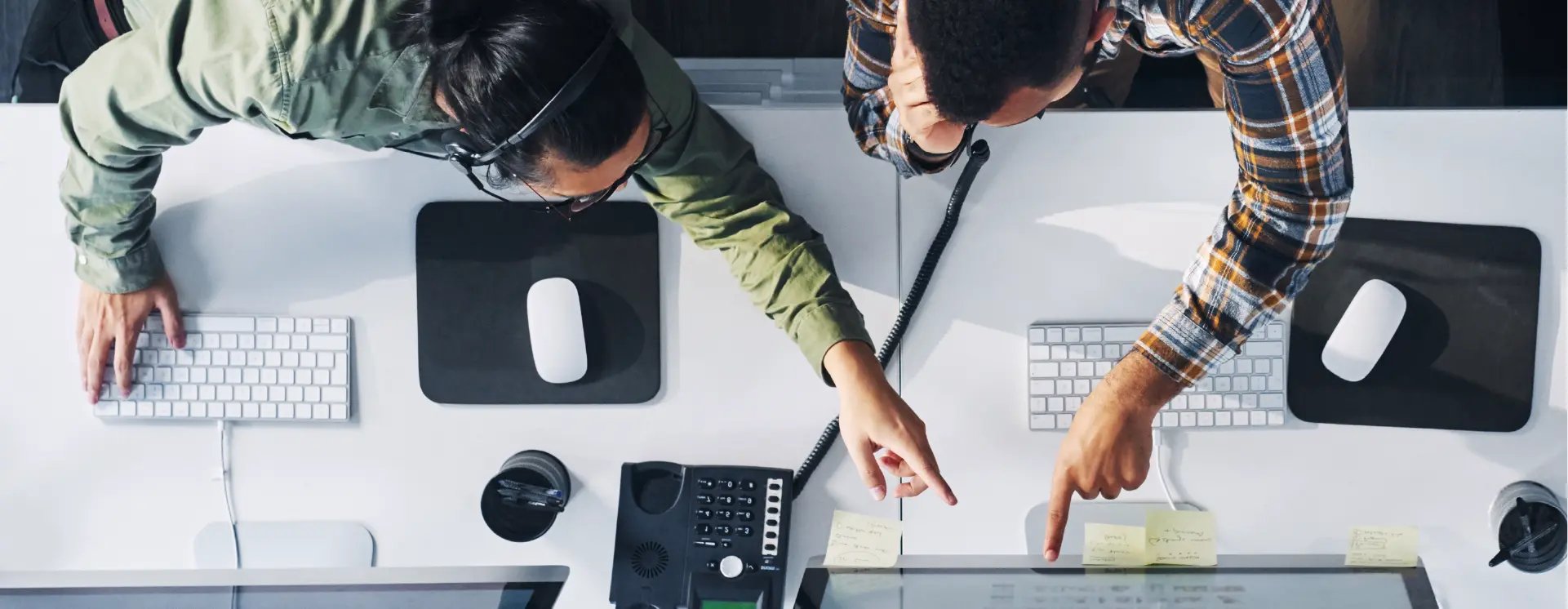 two-people-pointing-at-a-computer-screen