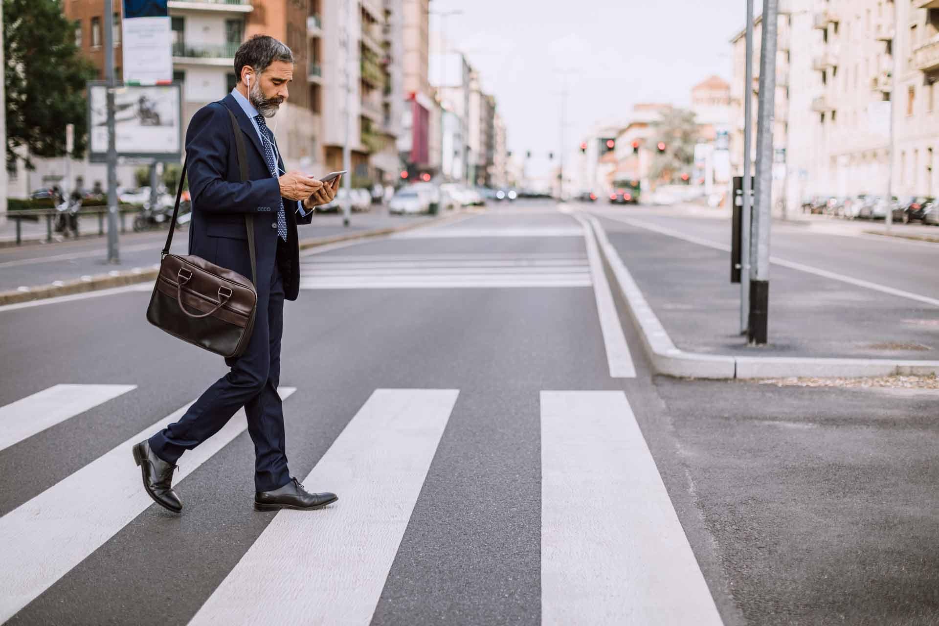 man_in_suit_walking_in_crosswalk_on_phone