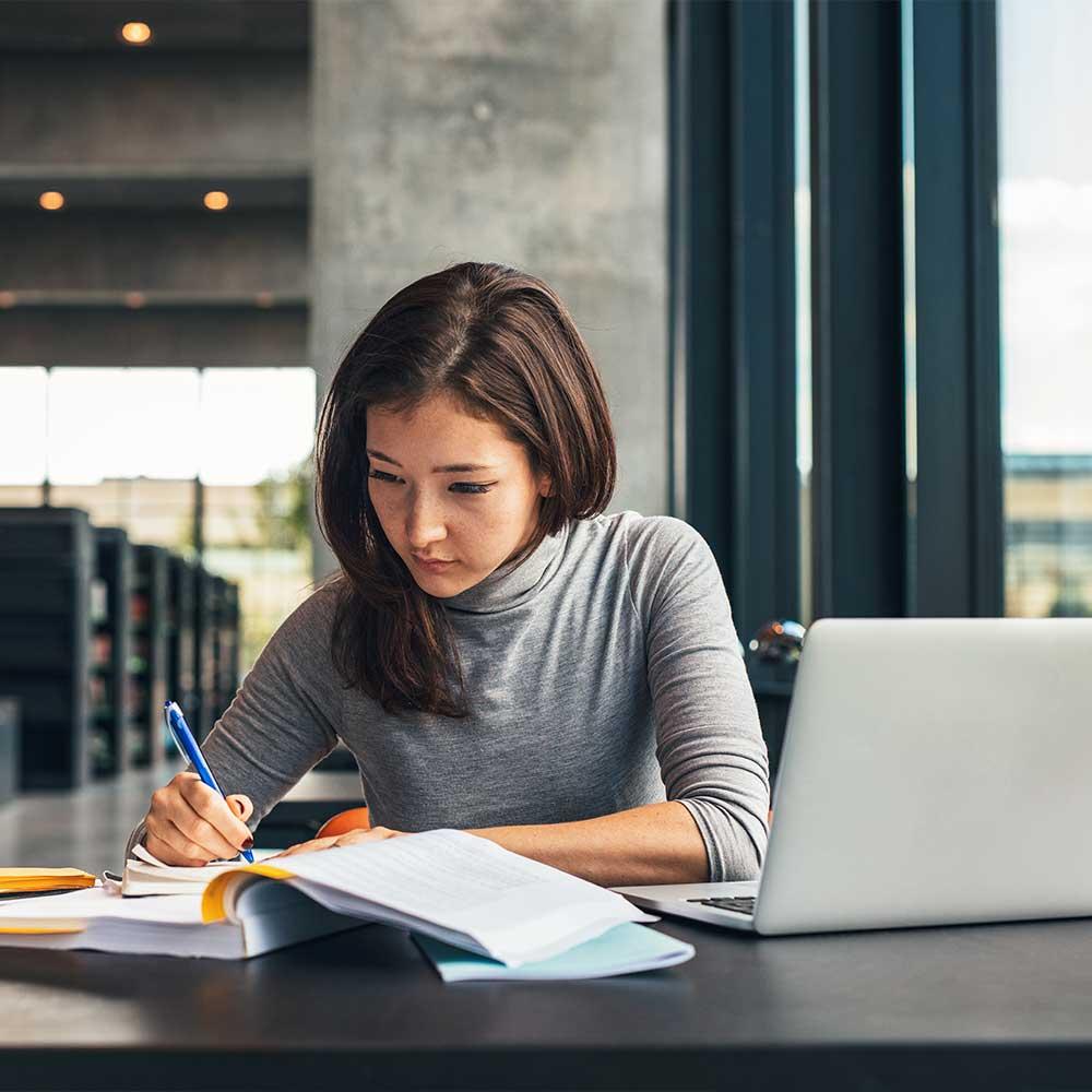 student_in_library_writing_notes