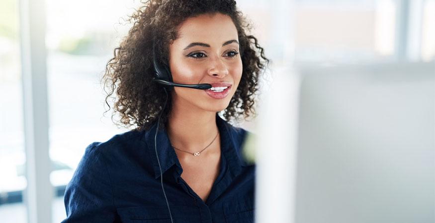 Woman with headset working on laptop