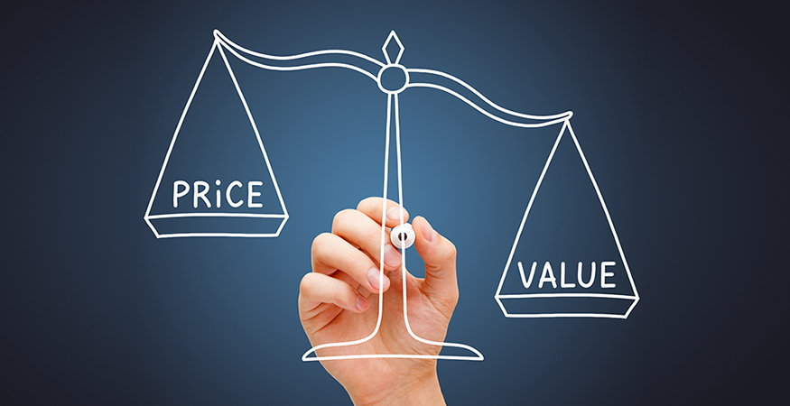 Price and value written in white being weighed by a scale in front of hand holding a marker