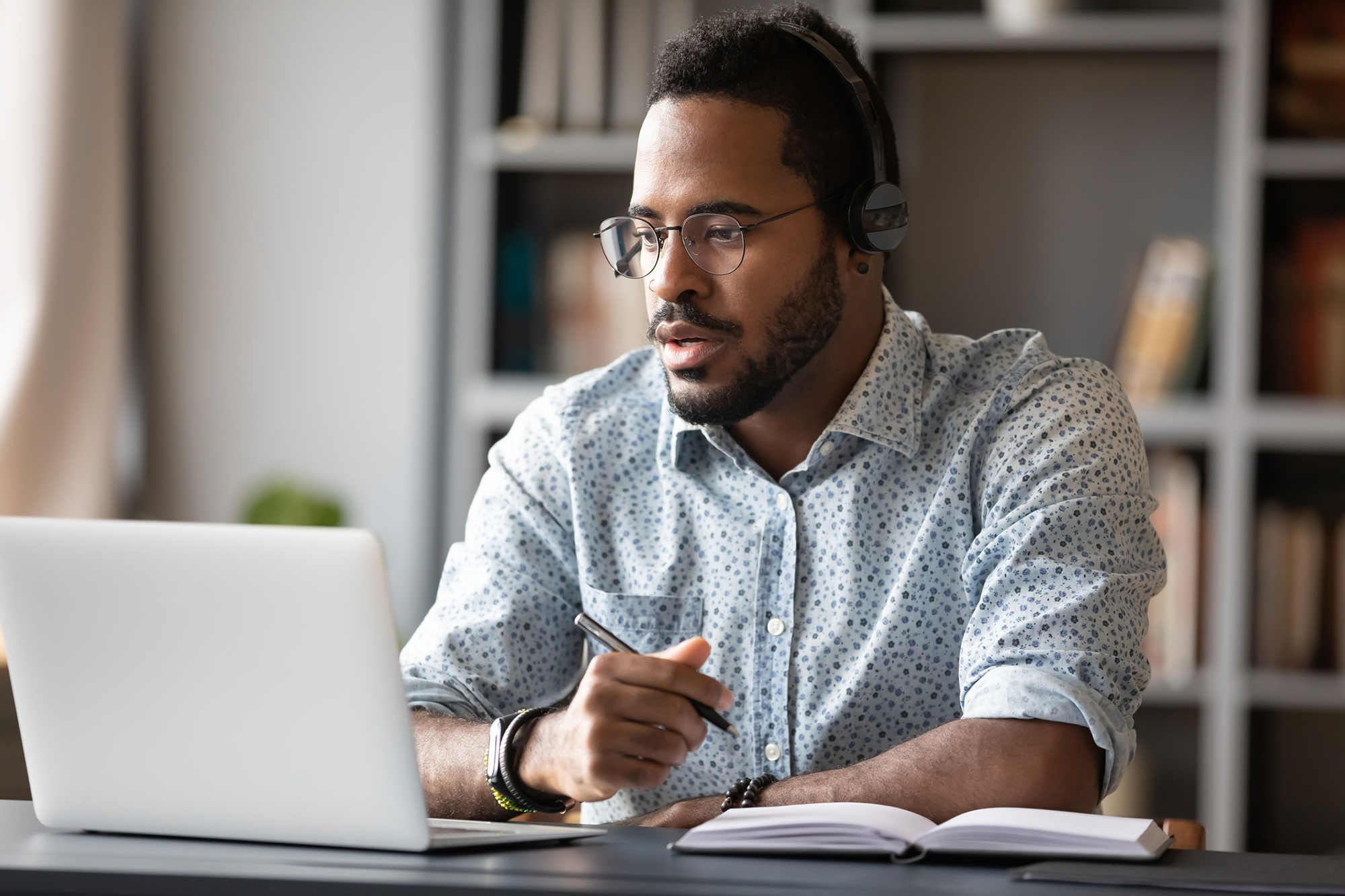 man on laptop taking notes