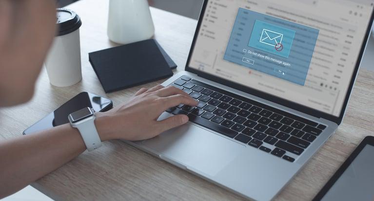 person typing on laptop with security alert on screen